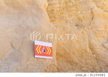 sign with warning of danger of collapsing cliffs sign with warning of danger of collapsing cliffs 91104983