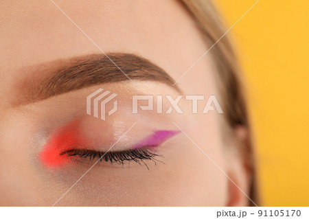 Model girl with makeup on yellow background, close up 91105170