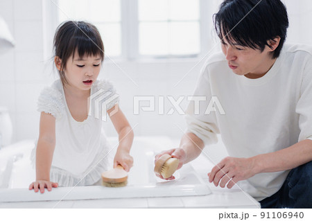 パパと一緒にお風呂掃除をする小さな女の子 91106940