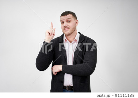 Excited businessman having an idea and pointing finger up at copy space over gray background 91111138