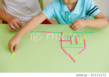 Teacher and preschool child building house on a table Teacher and preschool child building house on a table 91111272