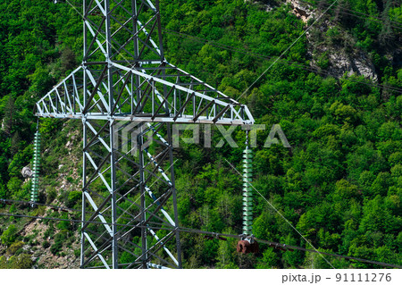 fragment of a power transmission pole close-up against the background of a wooded mountain slope 91111276