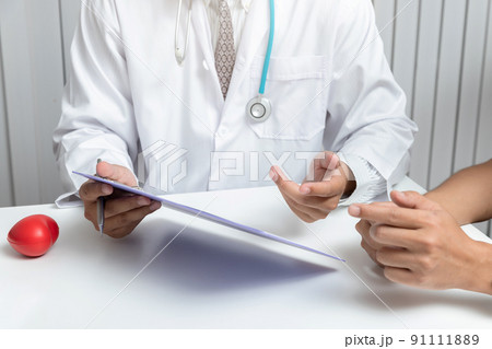 A doctor consults patient while sitting at the table in office. Medicine and health care concept. A doctor consults patient while sitting at the table in office. Medicine and health care concept. 91111889