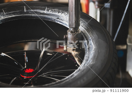 Wheel with tire on tire changing machine in auto repair service. 91111900