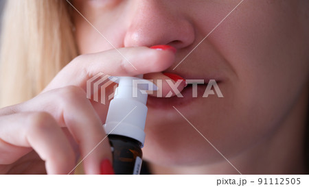 Woman instilling her nose with vasoconstrictor drops closeup 91112505