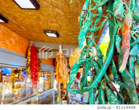 hot, red and green peppers are dried and hang on the counter. vegetables, vegan food, healthy food. pepper with green tail 91114408