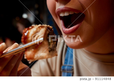 Cropped young woman 20s wear casual clothes hold in hand makizushi sushi roll served on plate traditional japanese food. Cropped young woman 20s wear casual clothes hold in hand makizushi sushi roll served on plate traditional japanese food. 91114848