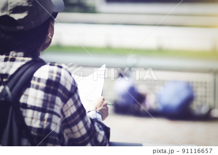 競馬新聞を持つ女性 91116657