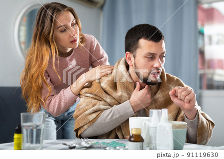 Woman comforting her ill husband at home Woman comforting her ill husband at home 91119630