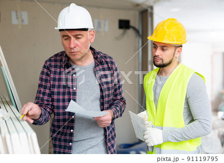 Civil engineer giving instructions to foreman in building under renovation 91119795
