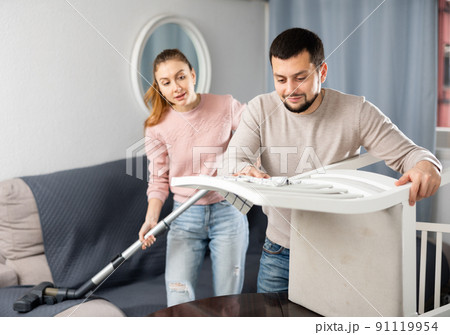 Young couple cleaning table in living room 91119954