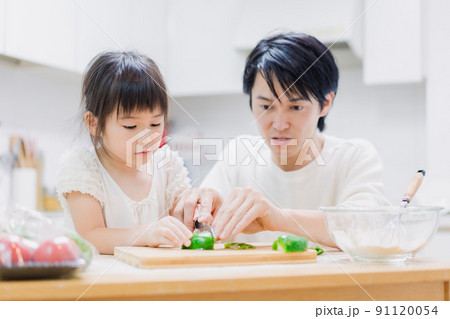 パパと一緒にクッキングをする小さな女の子 パパと一緒にクッキングをする小さな女の子 91120054