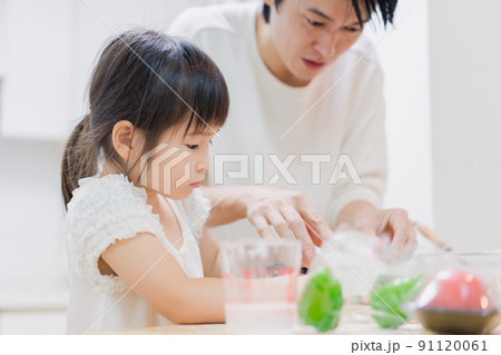 パパと一緒にクッキングをする小さな女の子 パパと一緒にクッキングをする小さな女の子 91120061