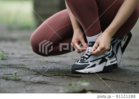 ランニング・スニーカーの靴紐を結ぶ女性 ランニング・スニーカーの靴紐を結ぶ女性 91121288