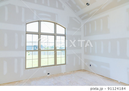 In an empty apartment room renovating a new house under construction, we are finishing the walls with putty In an empty apartment room renovating a new house under construction, we are finishing the walls with putty 91124184