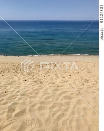 鳥取砂丘の砂紋と青く穏やかな山陰の海 91124385