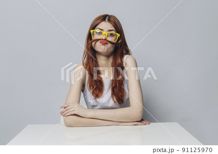 Caucasian woman sitting at table making a mustache with hair 91125970