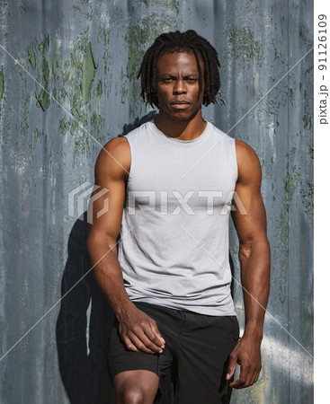 Portrait of athletic man against wall Portrait of athletic man against wall 91126109