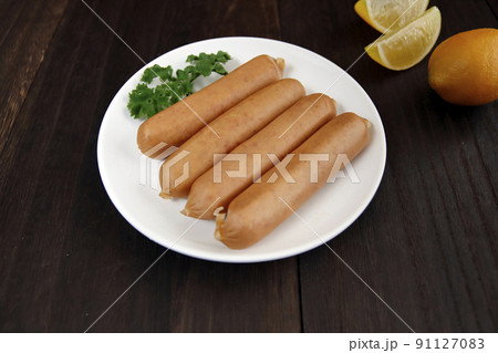 テーブルの上にあるドイツの伝統料理の豚肉を腸詰しパセリを添えたフランクフルトのようなソーセージ 91127083