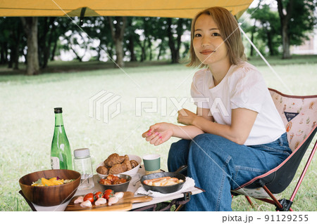 キャンプ・アウトドアで食事をする女性 91129255