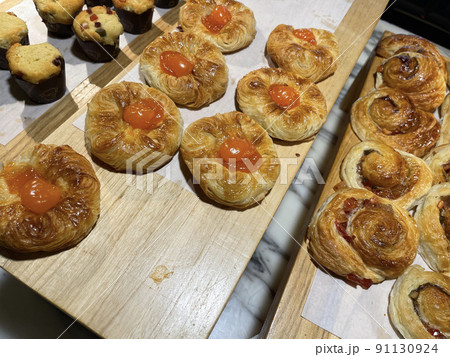Close up group of fresh baked sweet puff pastry stuffed with apricot and peach , super delicious warm fresh buttery sweet puff pastry stuffed with apricot and peach, French and American baked pastries 91130924