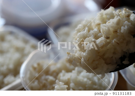 保存容器に小分けにしている炊き立ての押し麦入りご飯 91131183