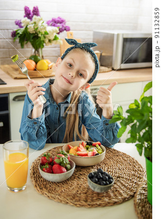 Cute little girl eats fruit salad 91132859