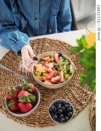 Cute little girl eats fruit salad 91132861