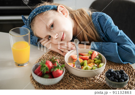 Cute little girl eats fruit salad 91132863