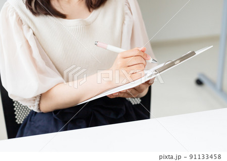 .書類に記入・チェックしている女性 91133458