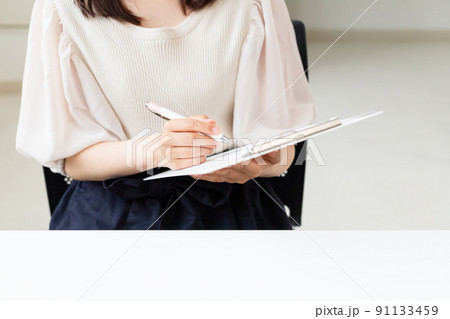 .書類に記入・チェックしている女性 .書類に記入・チェックしている女性 91133459