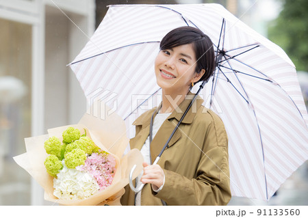 雨の日　紫陽花を持って歩く女性 91133560