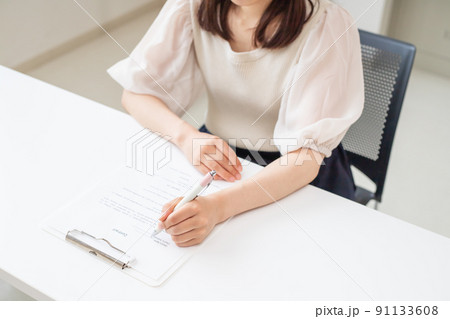.書類にサインをしている女性の手元 91133608