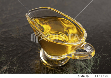Bowl with olive oil on black wood background. 91134350
