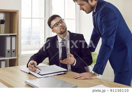 Insurance agent or lawyer giving consultation to young man during their meeting in office 91136110
