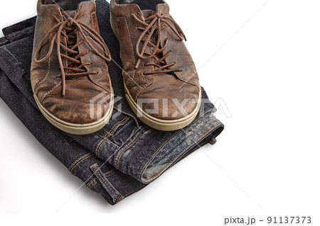 Stylishly distressed vintage brown leather shoes and black jeans isolated on white background Stylishly distressed vintage brown leather shoes and black jeans isolated on white background 91137373