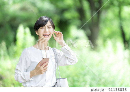 屋外でスマホを持つビジネスウーマン スマートフォンを持つ若い女性 屋外でスマホを持つビジネスウーマン スマートフォンを持つ若い女性 91138038