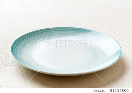 Perspective view of empty blue plate on cement background. Empty space for your design Perspective view of empty blue plate on cement background. Empty space for your design 91139300