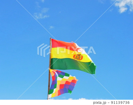 風にたなびくボリビア国旗とアイマラ族の旗 91139736