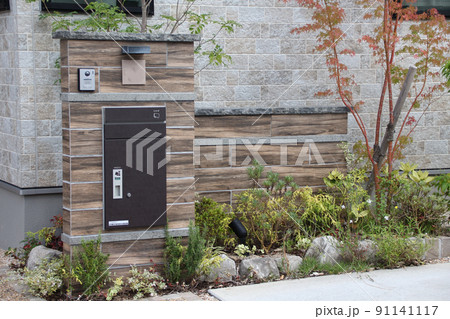 紅葉が美しく映える落ち着いた雰囲気の木目調タイル張りが品のある戸建て住宅の門柱 91141117