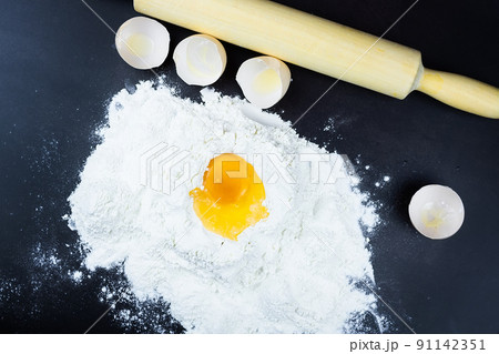 flour and egg on a black background. flour and egg on a black background. 91142351