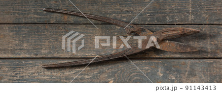 old metal garden shears on a wooden background 91143413