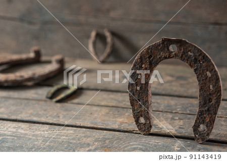 Old rusty horseshoe on a wooden background 91143419