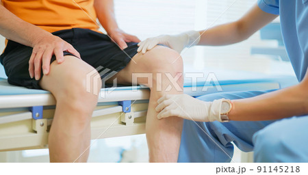 doctor examining patient knee doctor examining patient knee 91145218