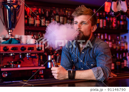 Vape. Vaping man in a cloud of vapor. Photo is taken in a vape bar. Vape. Vaping man in a cloud of vapor. Photo is taken in a vape bar. 91146790