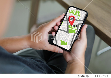 hand using a smartphone Holding GPS Map to Route Destination network connection Location Street Map with GPS Icons Navigation 91149793