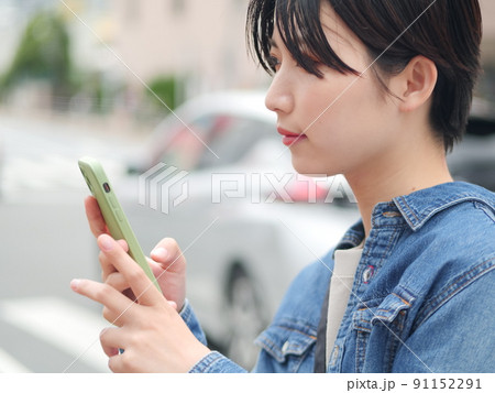 屋外でスマホを持つ女性 屋外でスマホを持つ女性 91152291