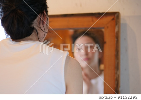 鏡を見る女性の後ろ姿 91152295