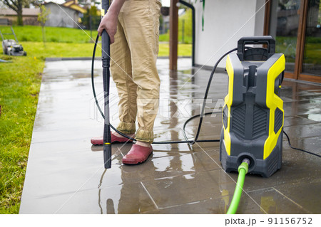 Pressure washer cleaning machine on wet concrete floor near the house build, cleaning terrace with a power washer Pressure washer cleaning machine on wet concrete floor near the house build, cleaning terrace with a power washer 91156752
