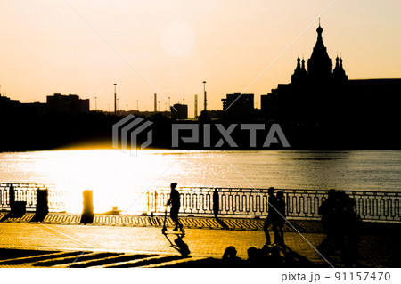 People silhouettes walking on quay of Nizhny Novgorod at sunset People silhouettes walking on quay of Nizhny Novgorod at sunset 91157470